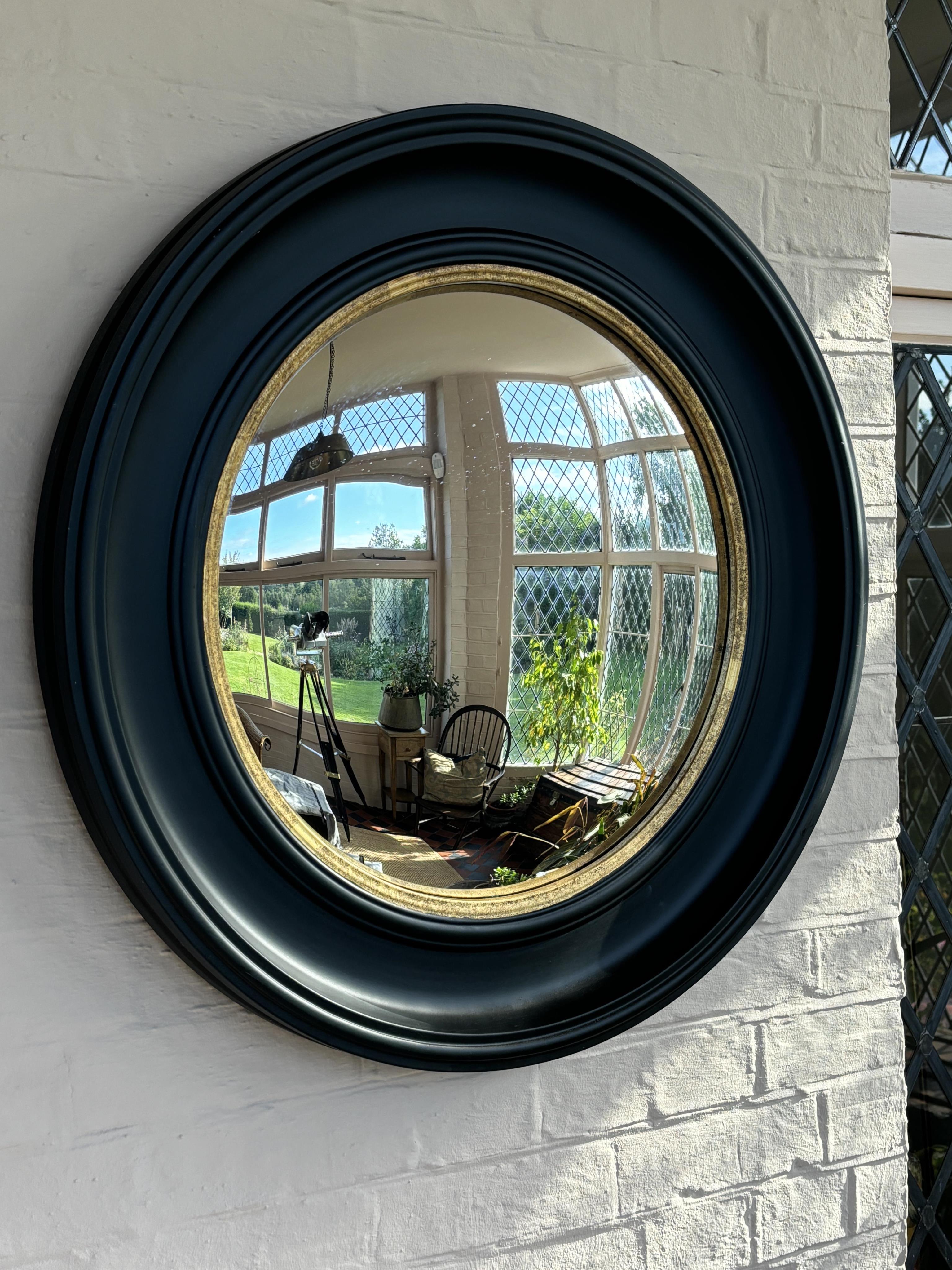 A reproduction ebonised circular convex wall mirror, diameter 73cm. Condition - good